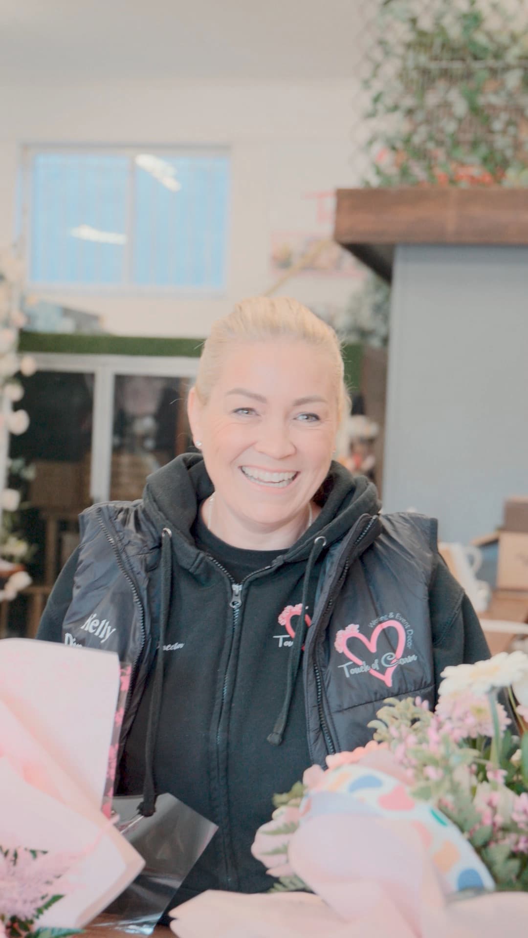 Kelly, a CapExpand customer, smiling outside her flower shop